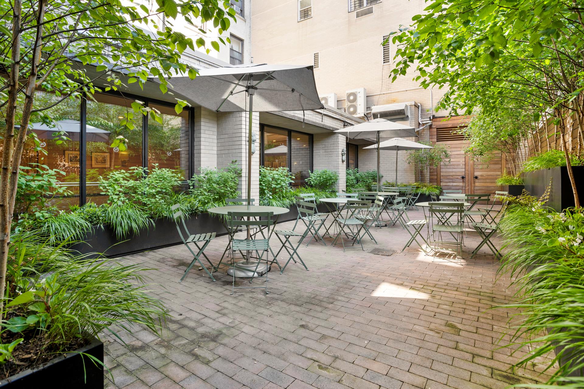 137 East 36th Street, Unit 5B Manhattan, NY 10016 - Photo 27 of 30 a view of a patio with table and chairs potted plants and large tree