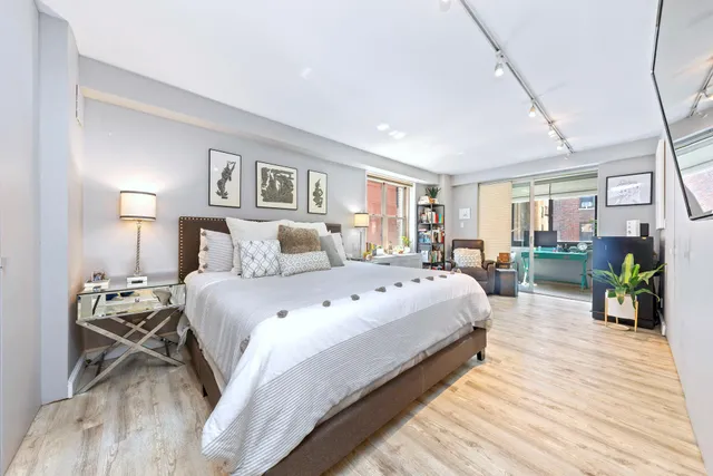 a bedroom with a bed and wooden floor