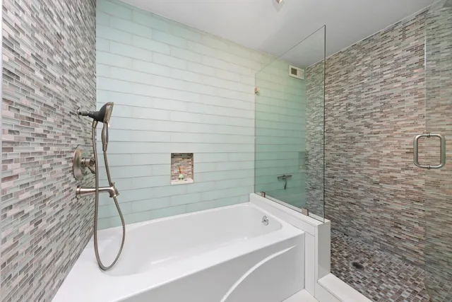 a bathroom with a white bath tub and shower