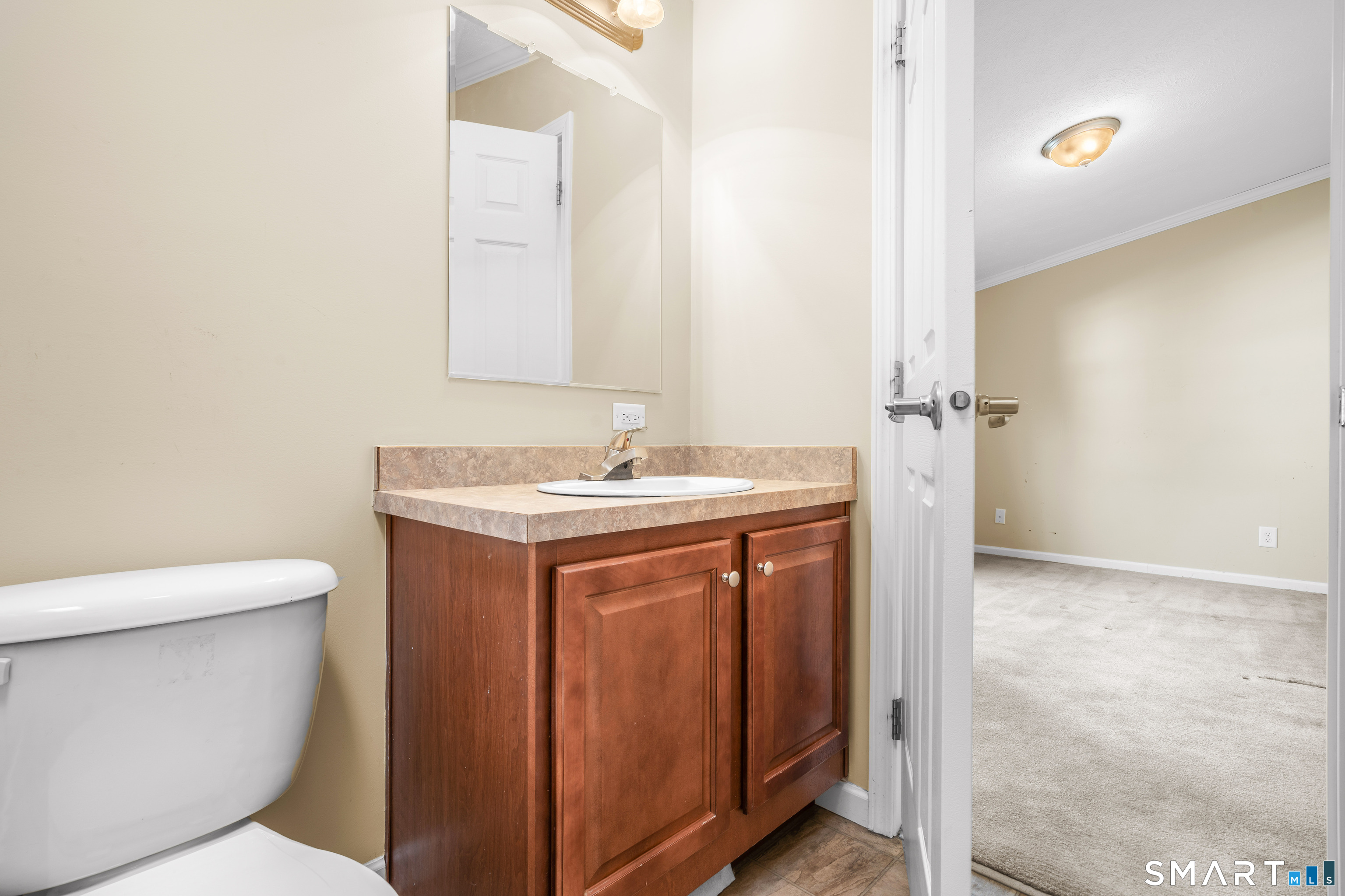 301 South Main Street Newtown, CT 06470 - Photo 21 of 23 a bathroom with a granite countertop toilet a sink and a mirror