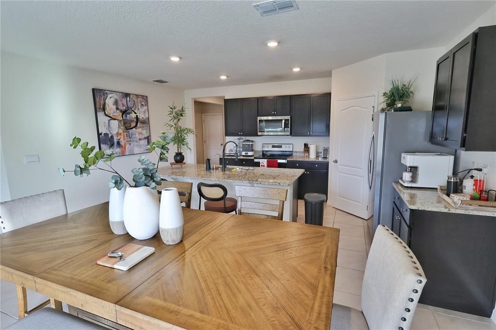 1724 Buckeye Road Davenport, FL 33837 - Photo 20 of 53 a dining room with furniture a window and kitchen view