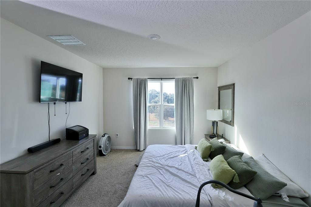 1724 Buckeye Road Davenport, FL 33837 - Photo 46 of 53 a bedroom with a bed and a flat tv screen on the dresser