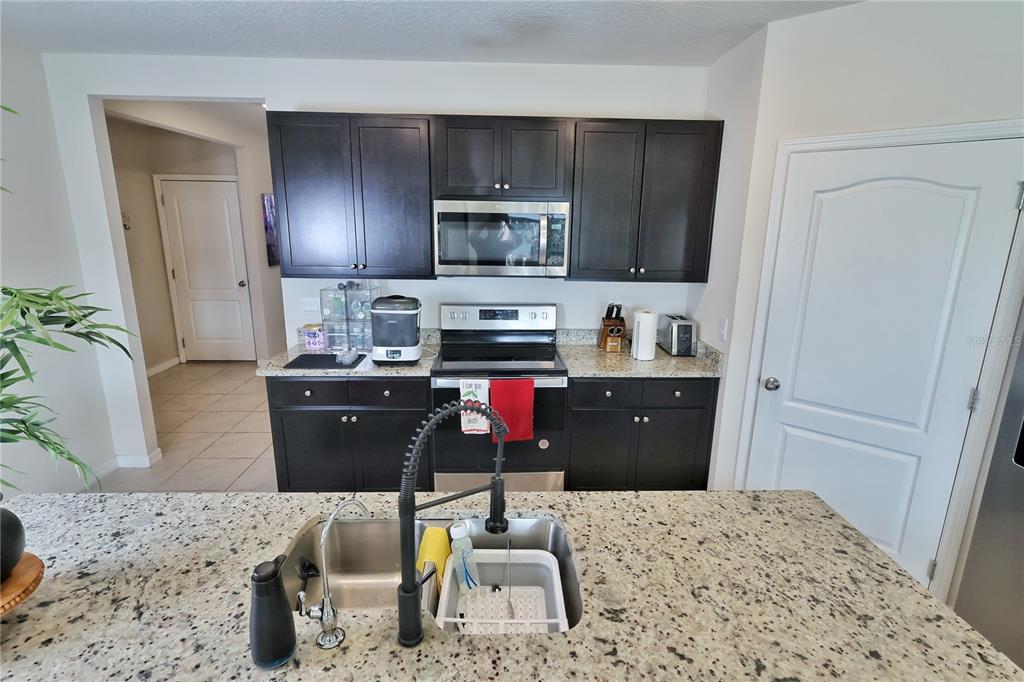 1724 Buckeye Road Davenport, FL 33837 - Photo 8 of 53 a kitchen with a refrigerator and a stove top oven