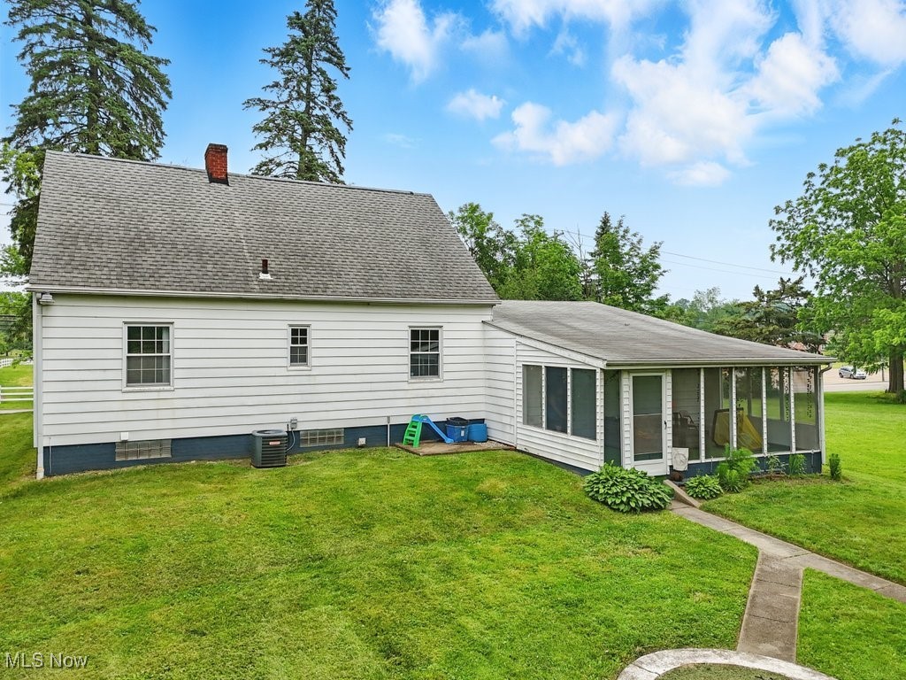 1624 Krumroy Road Akron, OH 44306 - Photo 3 of 47 Rear view of house featuring a sunroom, a chimney, a yard, and roof with shingles