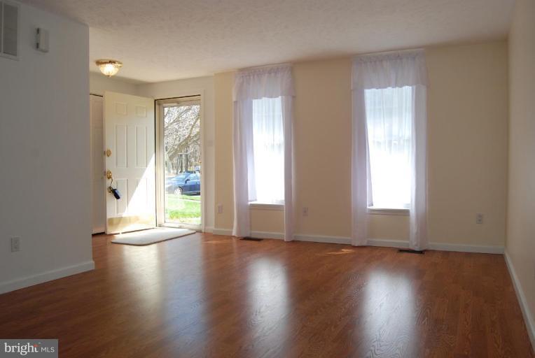 1488 Autumn Ridge Circle Reston, VA 20194 - Photo 7 of 30 a view of an empty room with wooden floor and a window