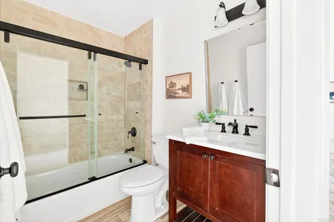a bathroom with a granite countertop sink toilet and shower