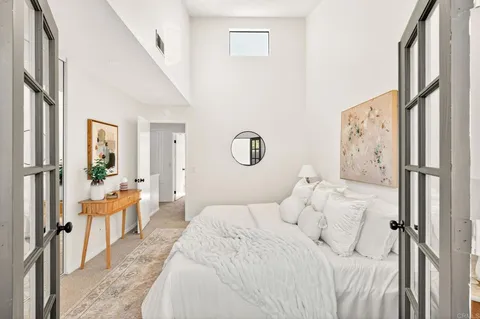 a bedroom with a large bed and a chandelier