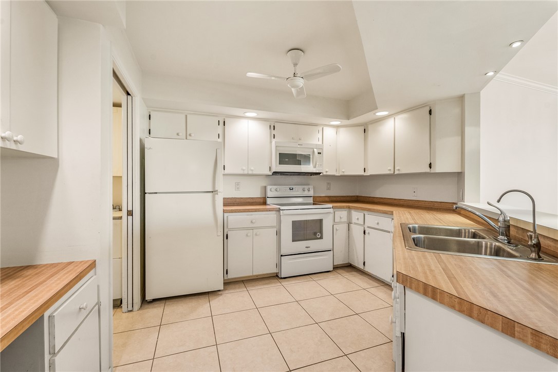 1850 Bay Road, Unit 3F Vero Beach, FL 32963 - Photo 15 of 34 a kitchen with white cabinets and white appliances