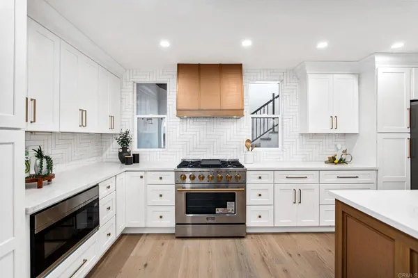 a kitchen with stainless steel appliances granite countertop a stove sink and cabinets