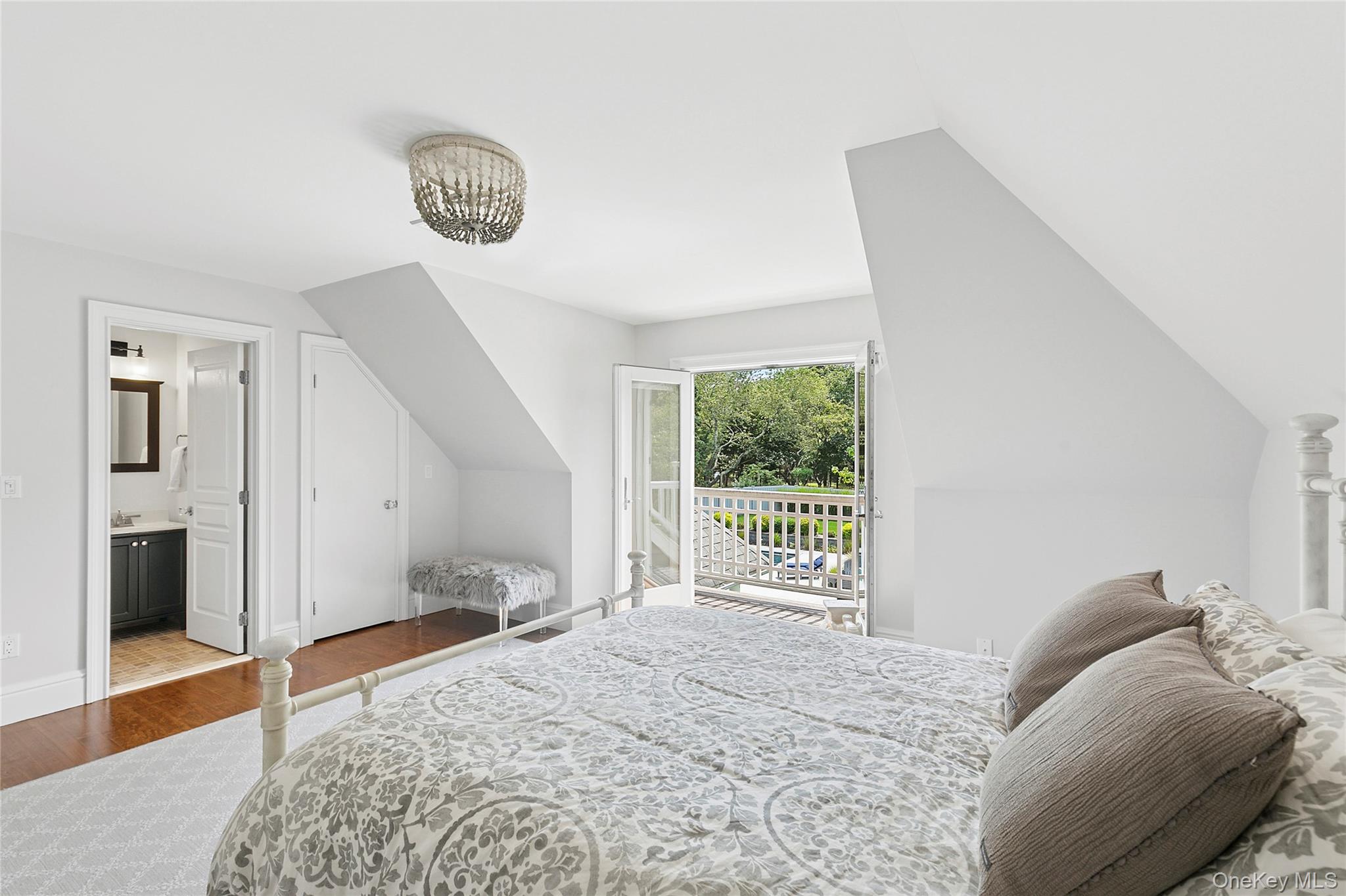 3470 North Bayview Road Southold, NY 11971 - Photo 11 of 25 Bedroom with wood finished floors, vaulted ceiling, access to exterior, and connected bathroom