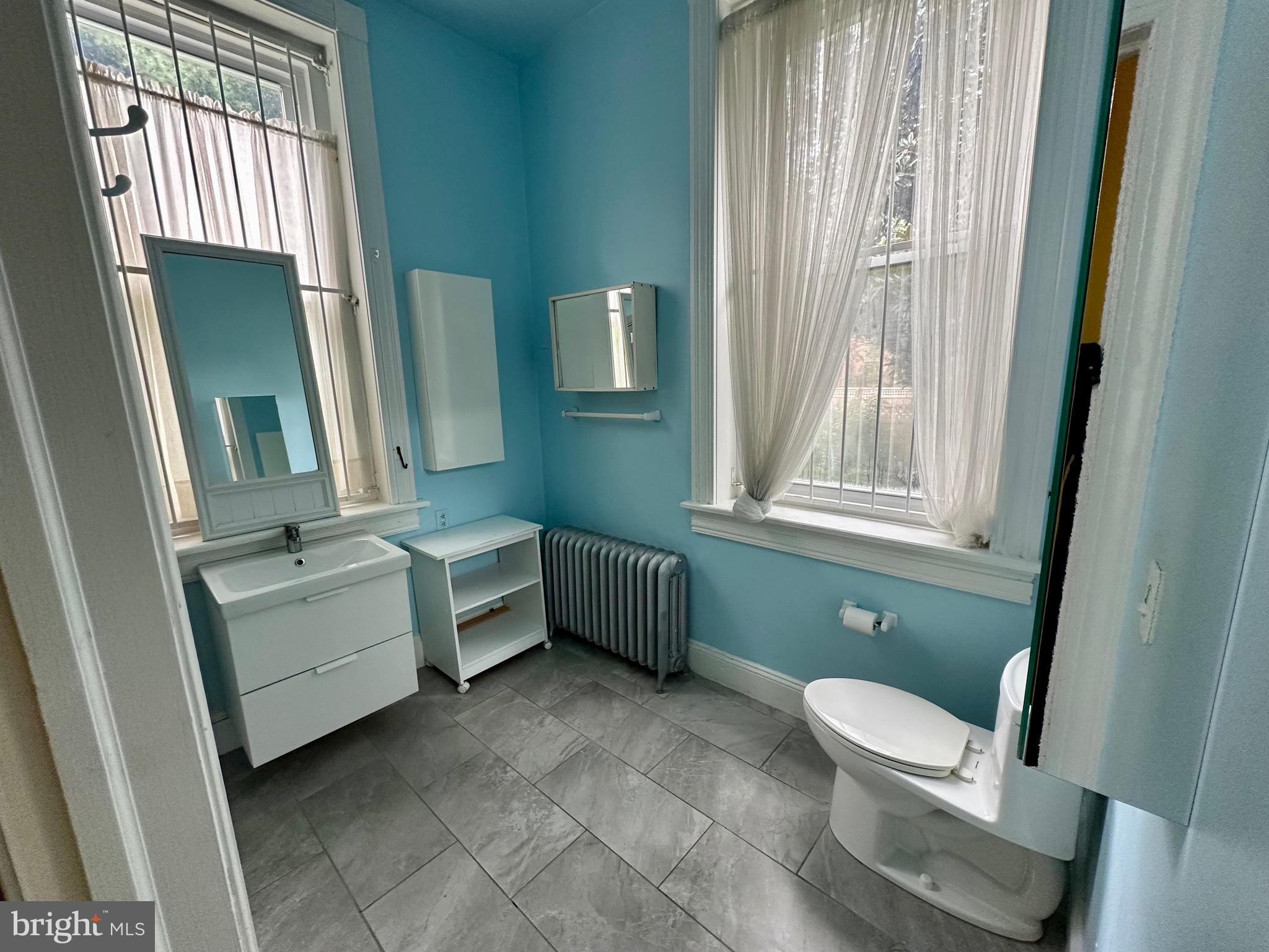 4805 Springfield Avenue Philadelphia, PA 19143 - Photo 18 of 22 a bathroom with a toilet sink and mirror