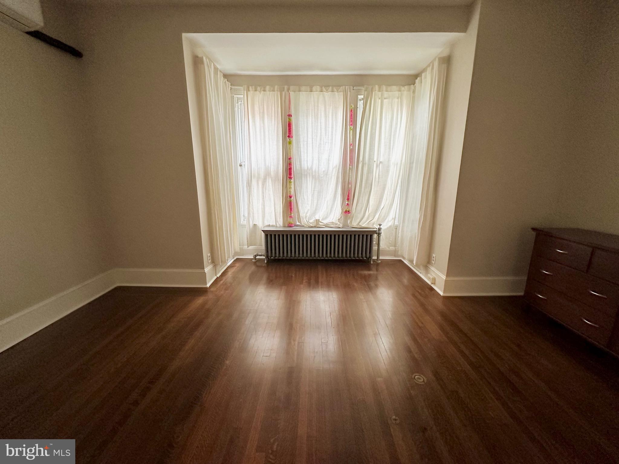 4805 Springfield Avenue Philadelphia, PA 19143 - Photo 8 of 22 an empty room with wooden floor and windows