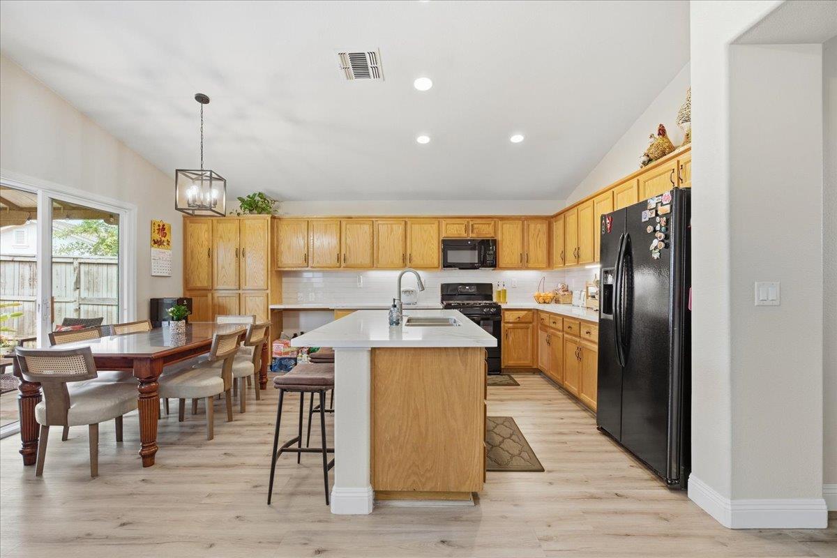 7821 Shell Beach Drive Antelope, CA 95843 - Photo 12 of 40 a kitchen with stainless steel appliances kitchen island granite countertop a table chairs and a refrigerator