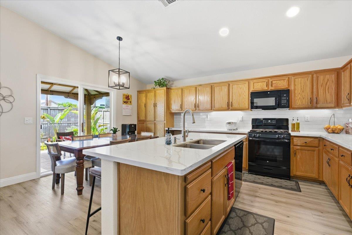7821 Shell Beach Drive Antelope, CA 95843 - Photo 13 of 40 a kitchen with a stove a sink a dining table and chairs