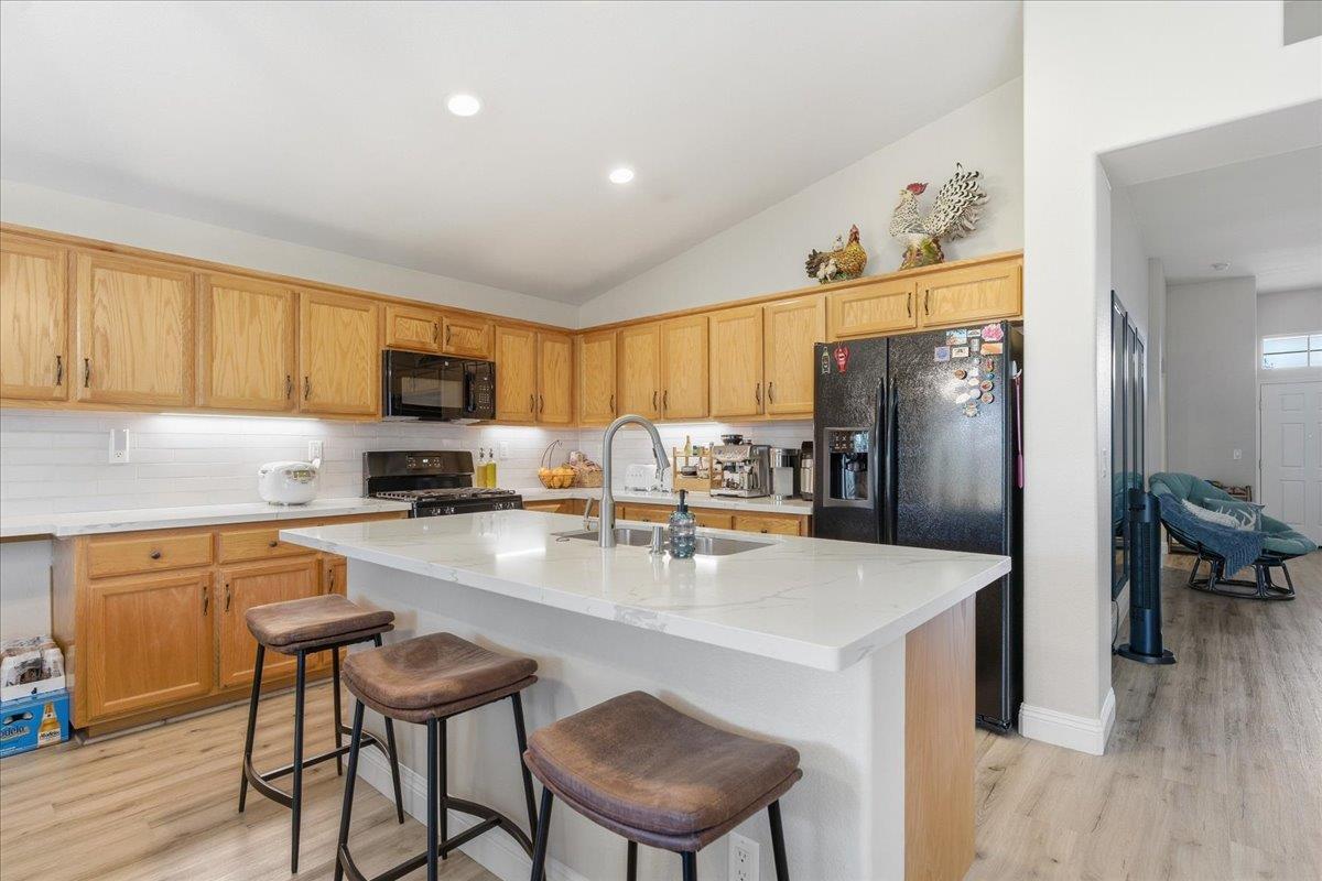 7821 Shell Beach Drive Antelope, CA 95843 - Photo 14 of 40 a kitchen with stainless steel appliances granite countertop a refrigerator a sink a stove and chairs with wooden floor