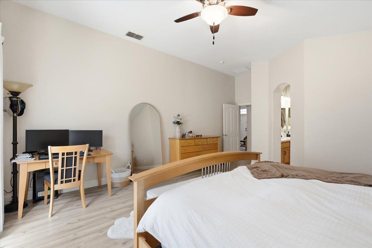 7821 Shell Beach Drive Antelope, CA 95843 - Photo 24 of 40 a bedroom with a bed desk and a chandelier