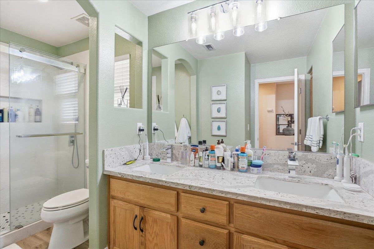 7821 Shell Beach Drive Antelope, CA 95843 - Photo 29 of 40 a bathroom with double vanity sink a toilet and a large mirror