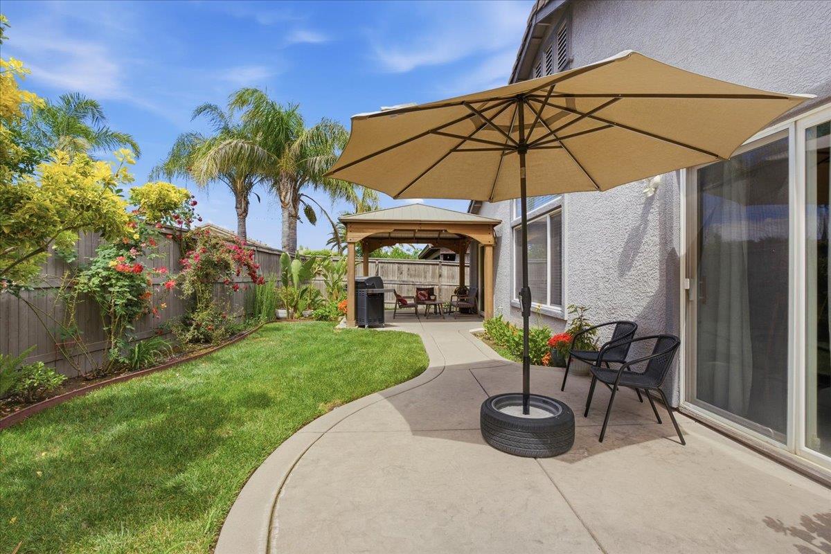 7821 Shell Beach Drive Antelope, CA 95843 - Photo 37 of 40 a view of a patio with a table and chairs under an umbrella