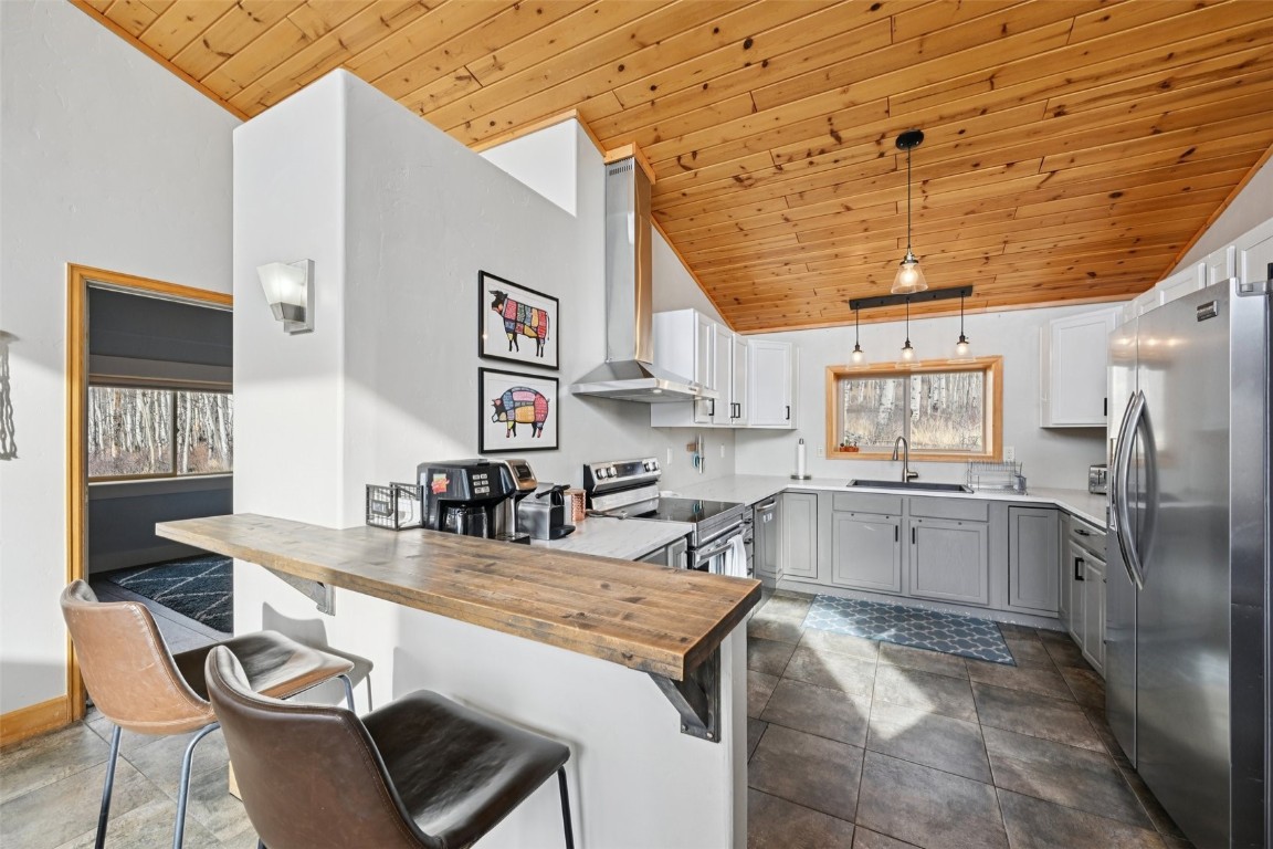 1499 Sheep Ridge Road Fairplay, CO 80440 - Photo 13 of 40 a kitchen with stainless steel appliances granite countertop a sink and dishwasher a refrigerator with wooden cabinets