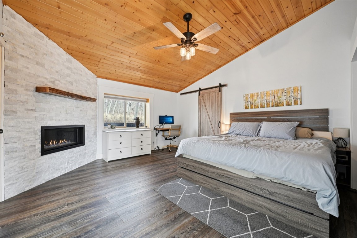 1499 Sheep Ridge Road Fairplay, CO 80440 - Photo 21 of 40 a spacious bedroom with a bed and a fireplace