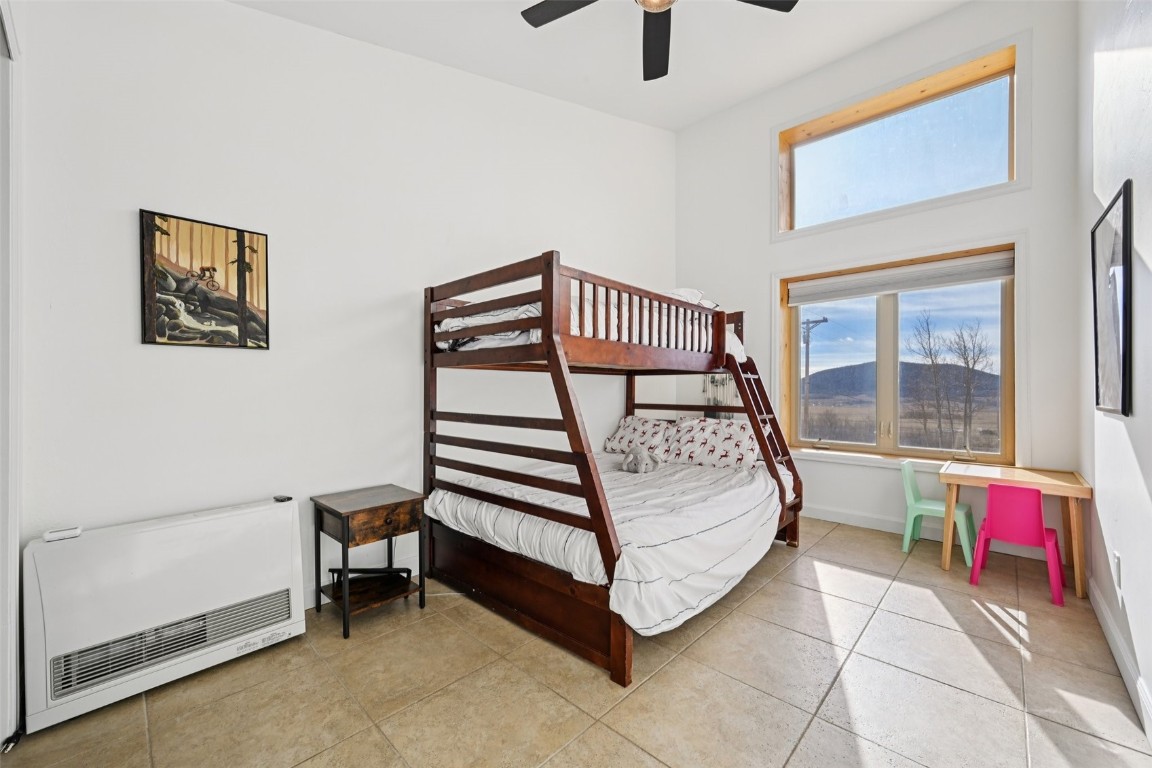 1499 Sheep Ridge Road Fairplay, CO 80440 - Photo 29 of 40 a bedroom with a bed and a chandelier