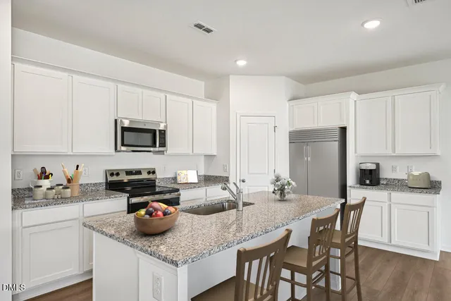 a kitchen with sink refrigerator stove and microwave