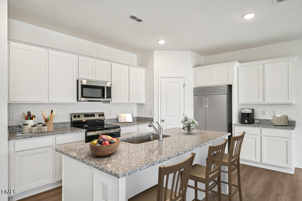 11287 Salers Loop Middlesex, NC 27557 - Photo 10 of 23 a kitchen with sink a microwave and cabinets