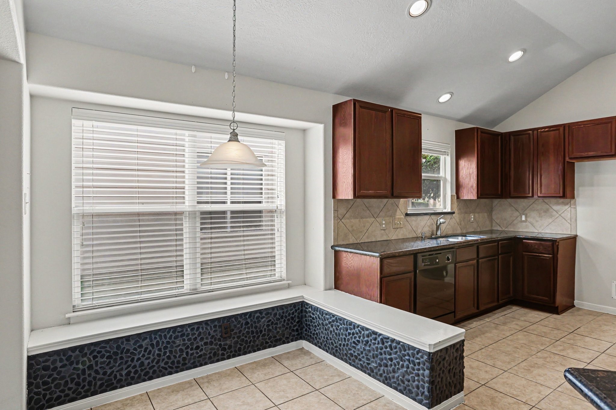 25222 Ginger Ranch Drive Katy, TX 77494 - Photo 10 of 33 Breakfast nook with custom built-in stone bench. The space is brightened by recessed lighting and a hanging pendant light.