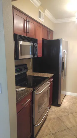 a kitchen with granite countertop stainless steel appliances and wooden cabinets