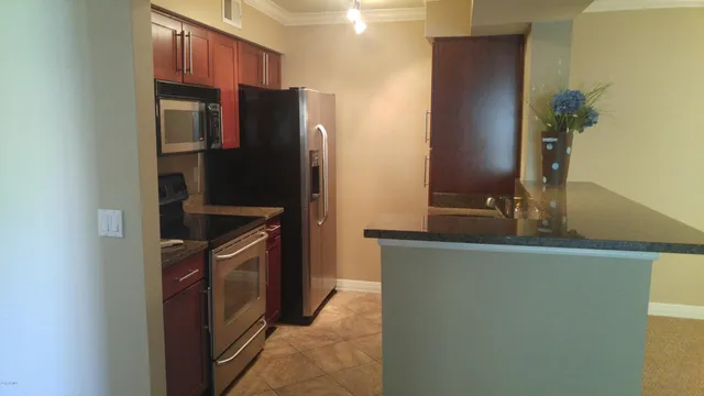 a kitchen with stainless steel appliances granite countertop a refrigerator and a stove
