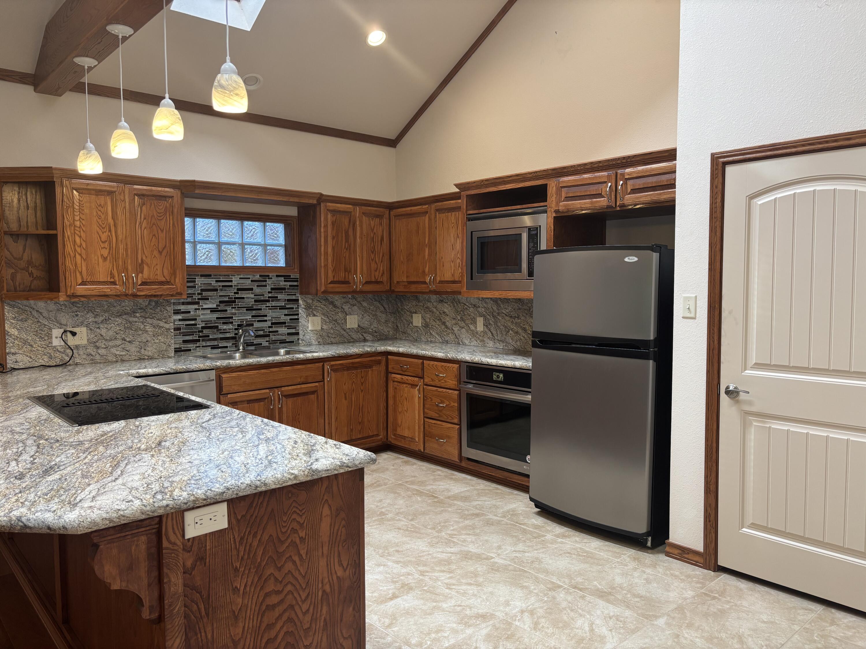 33 West Lakeshore Drive Ransom Canyon, TX 79366 - Photo 20 of 48 a kitchen with granite countertop a refrigerator and a sink