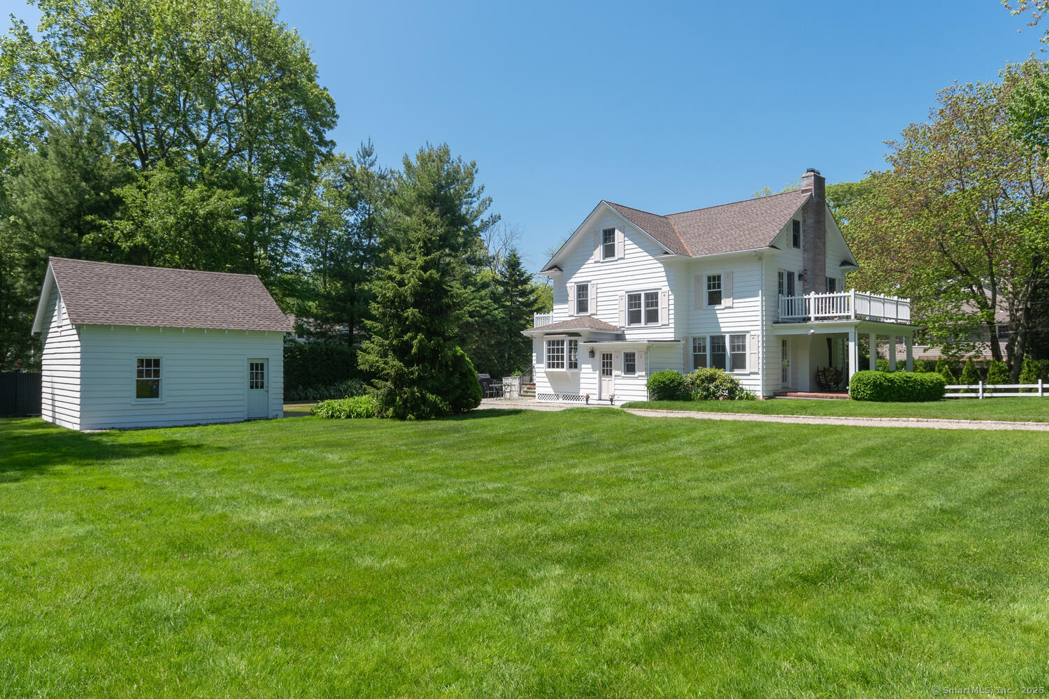 128 5 Mile River Road Darien, CT 06820 - Photo 17 of 23 a front view of a house with a garden and trees