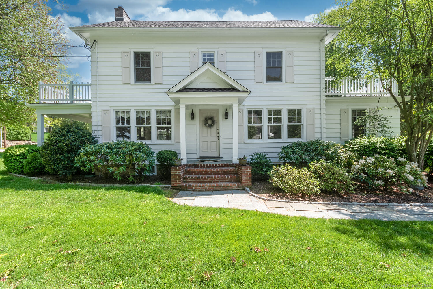 128 5 Mile River Road Darien, CT 06820 - Photo 3 of 23 a front view of a house with a garden