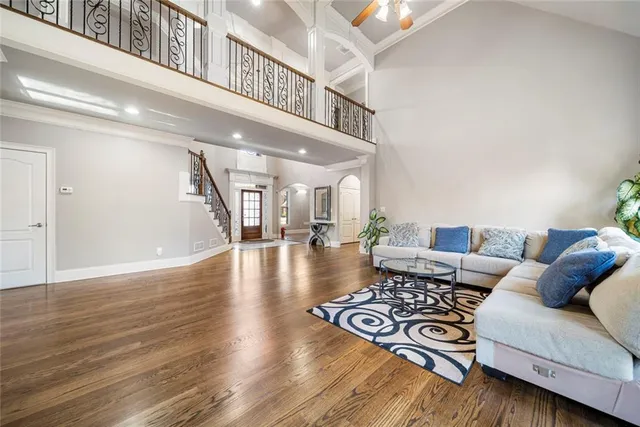a living room with stainless steel appliances granite countertop furniture wooden floor and a view of kitchen