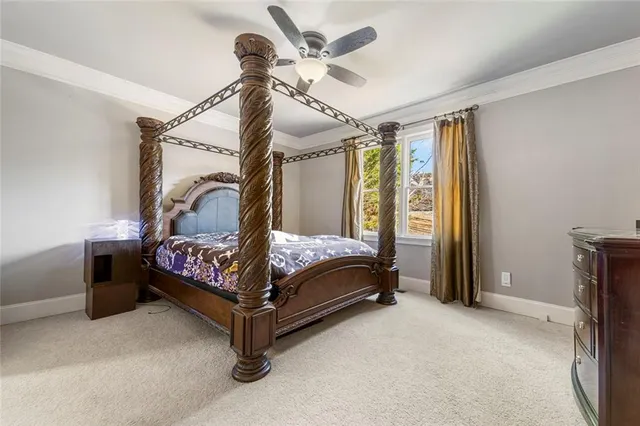 a bed sitting in a bedroom next to a window and a chandelier
