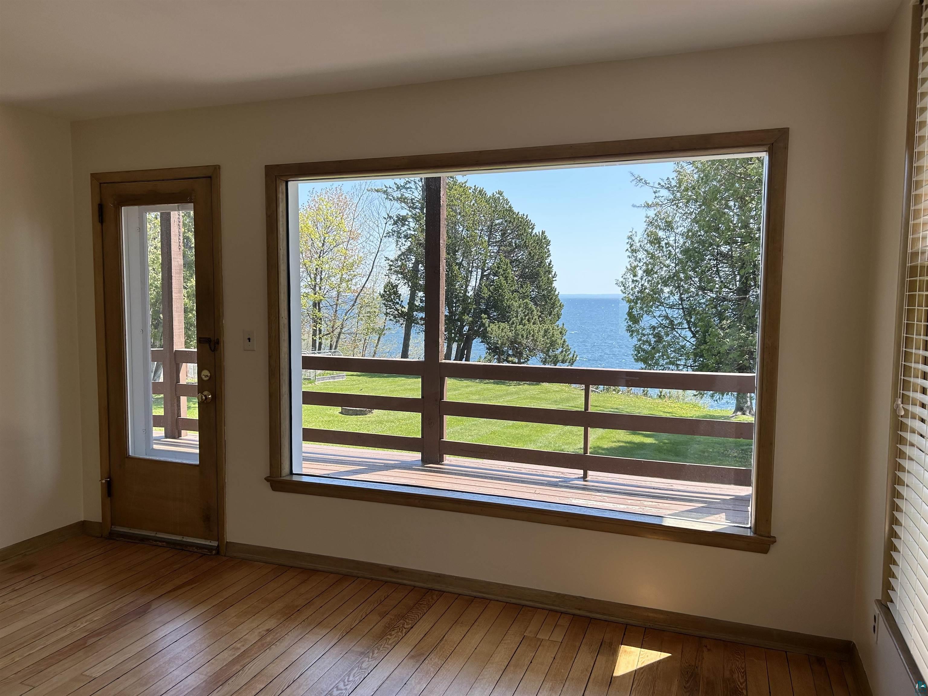 5090 London Road, Unit 1 Duluth, MN 55804 - Photo 24 of 54 Expansive window framing a water vista, complemented by a wood-finish floor