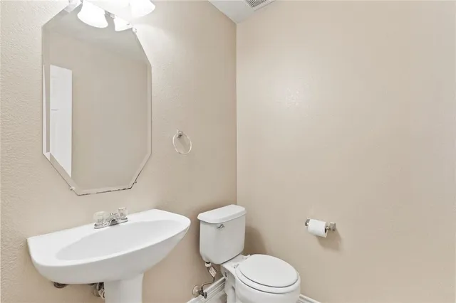 a bathroom with a sink a toilet and a mirror