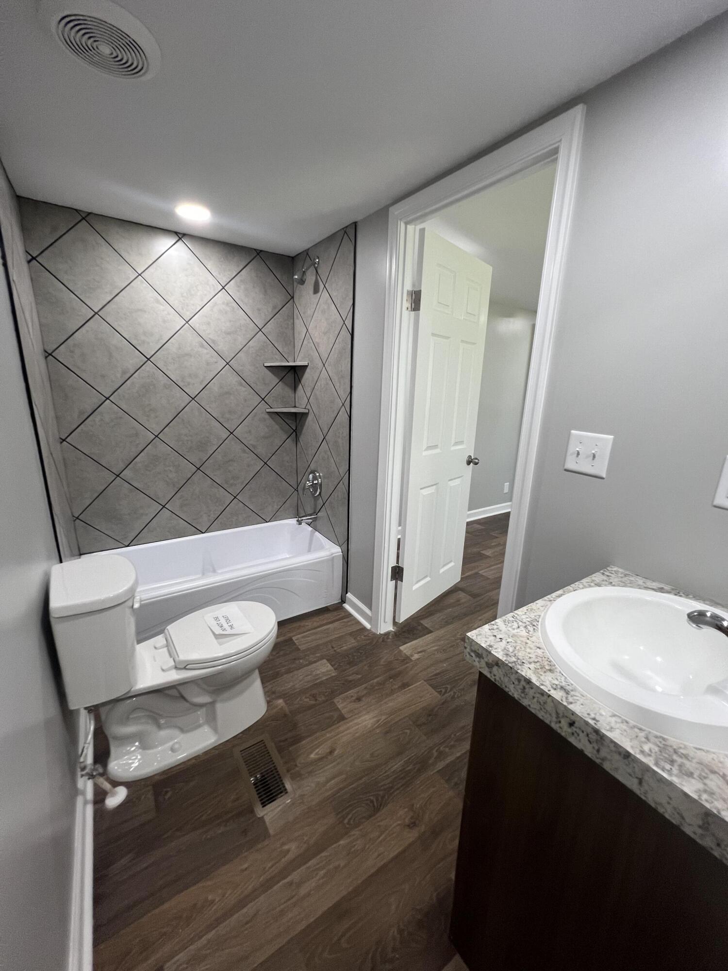 203 Byrnes Street Goodview, VA 24095 - Photo 10 of 13 a bathroom with a granite countertop sink toilet and shower