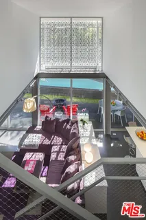 a room with furniture book shelf and a floor to ceiling window