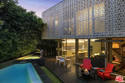 a roof deck with table and chairs with wooden floor and fence