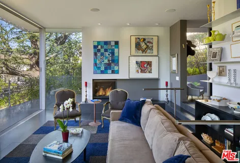 a living room with furniture cabinets and wooden floor