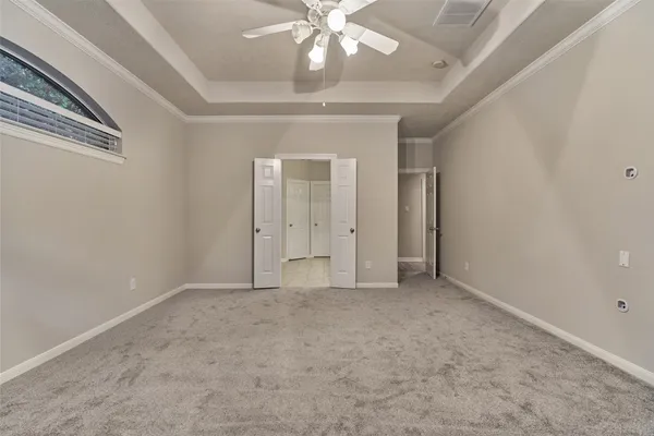 a view of an empty room with chandelier fan