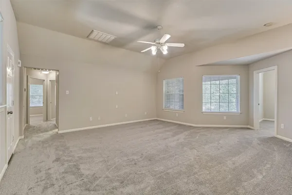 an empty room with windows and fan