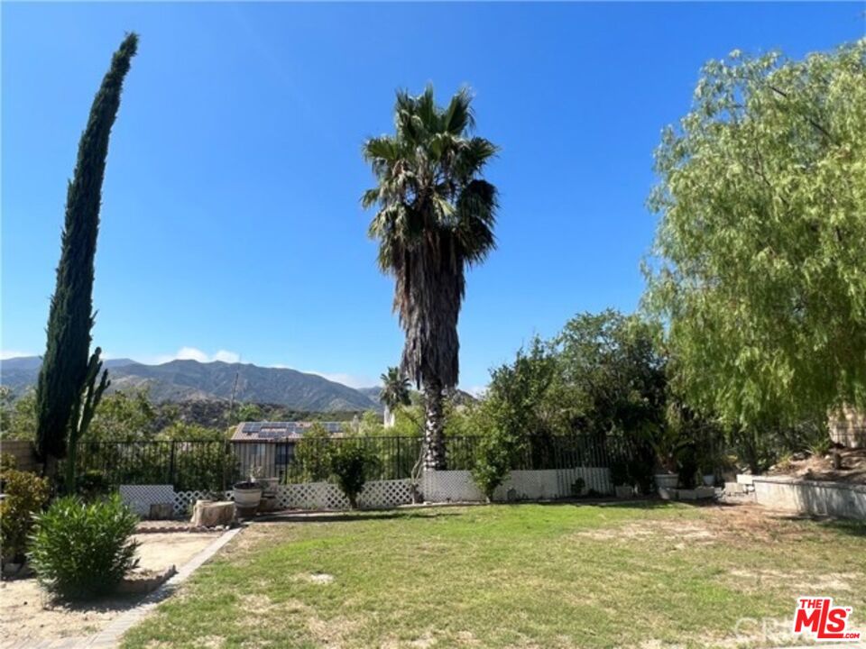 26526 Beecher Lane Stevenson Ranch, CA 91381 - Photo 29 of 31 a front view of a house with a yard and palm trees