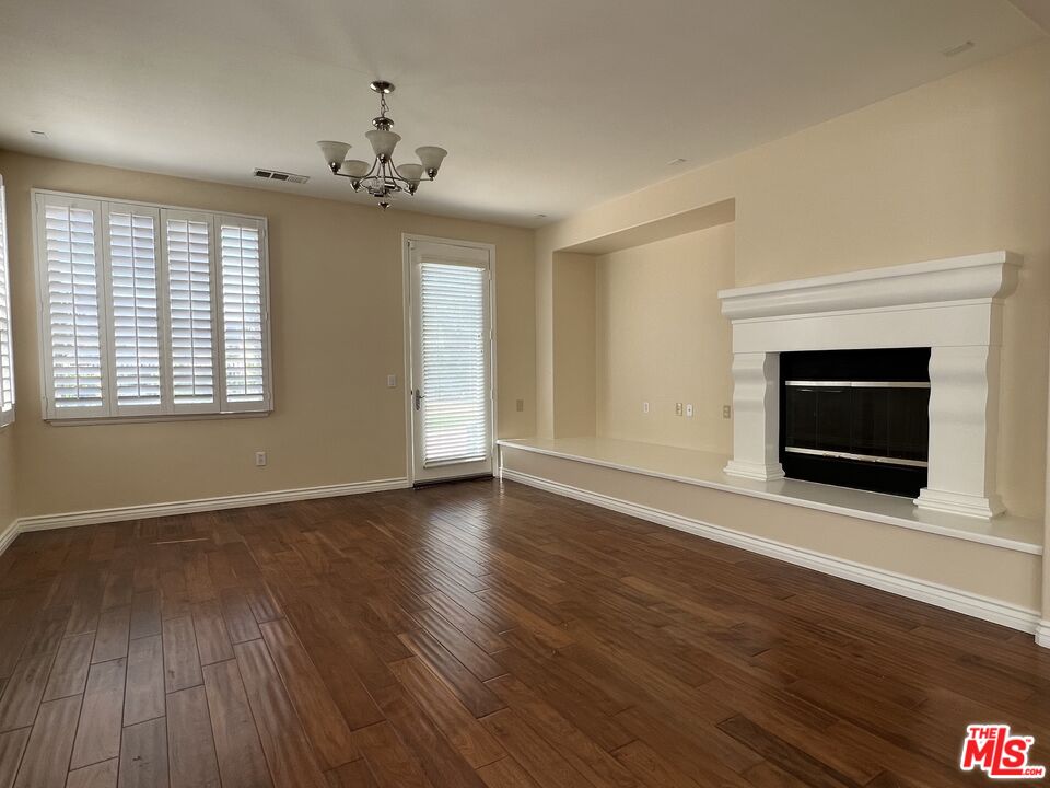 26526 Beecher Lane Stevenson Ranch, CA 91381 - Photo 8 of 31 a view of an empty room with wooden floor fireplace and a window