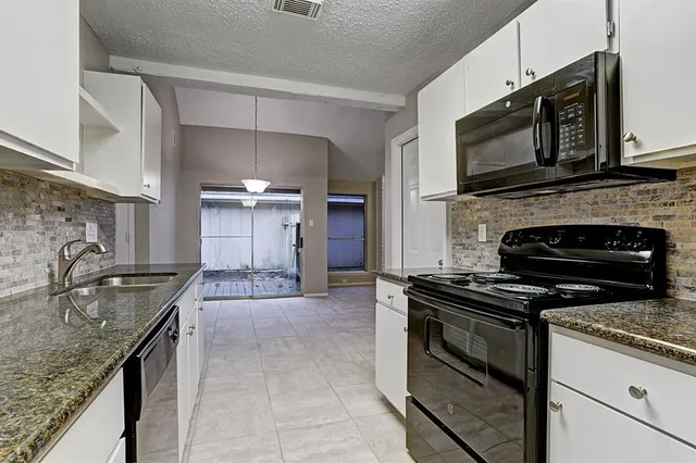 a kitchen with granite countertop a stove and a sink