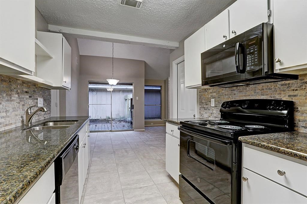 23322 Pebworth Place Spring, TX 77373 - Photo 6 of 10 a kitchen with granite countertop a stove and a sink