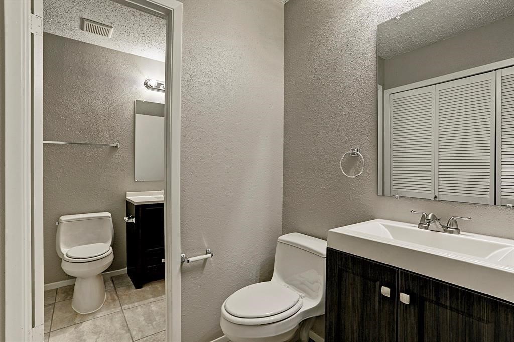 23322 Pebworth Place Spring, TX 77373 - Photo 9 of 10 a bathroom with a toilet a sink a mirror and vanity