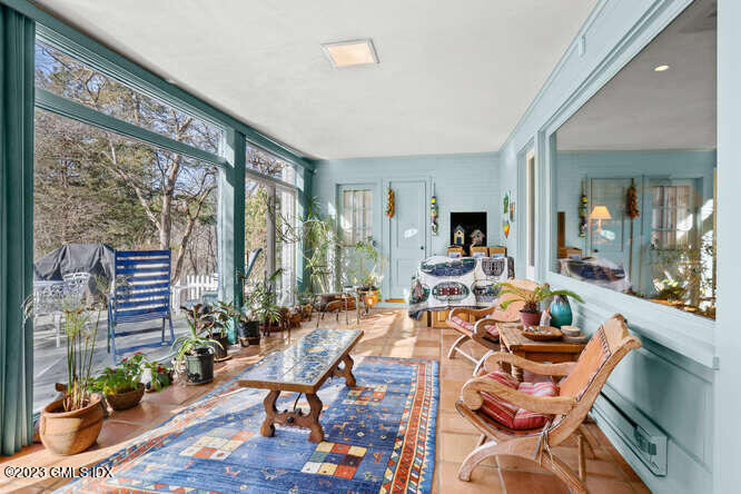 320 Cognewaugh Road Cos Cob, CT 06807 - Photo 11 of 38 a living room with furniture a fireplace and a floor to ceiling window