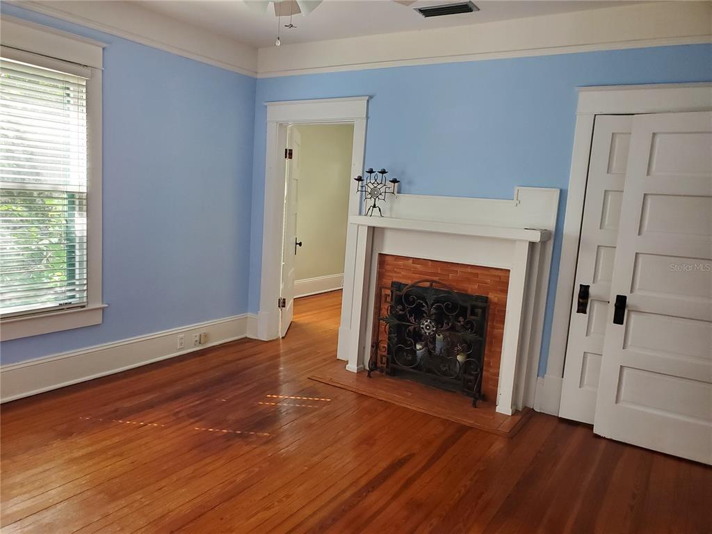 516 Northeast 4 Street Gainesville, FL 32601 - Photo 41 of 57 an empty room with wooden floor fireplace and windows